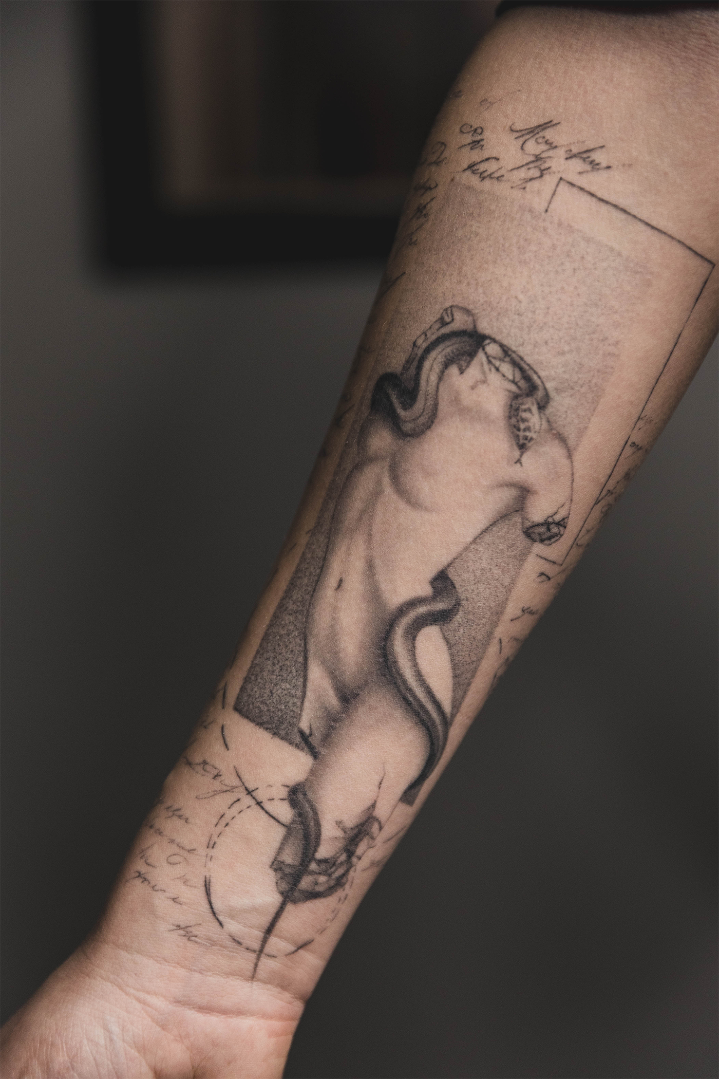 Sort/grå tatovering med fine detaljer og dybde med mikrorealistiske motiver
