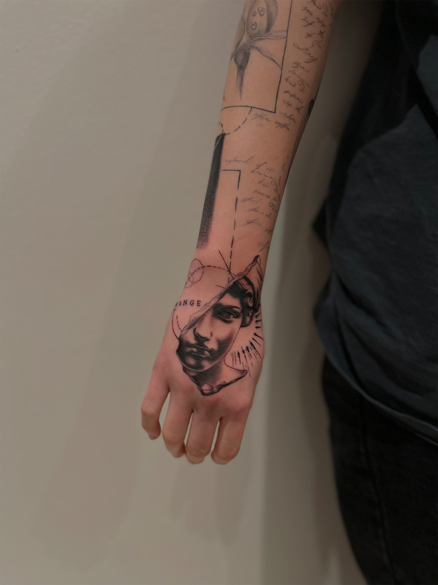 Sort/grå tatovering med fine detaljer og dybde med mikrorealistiske motiver