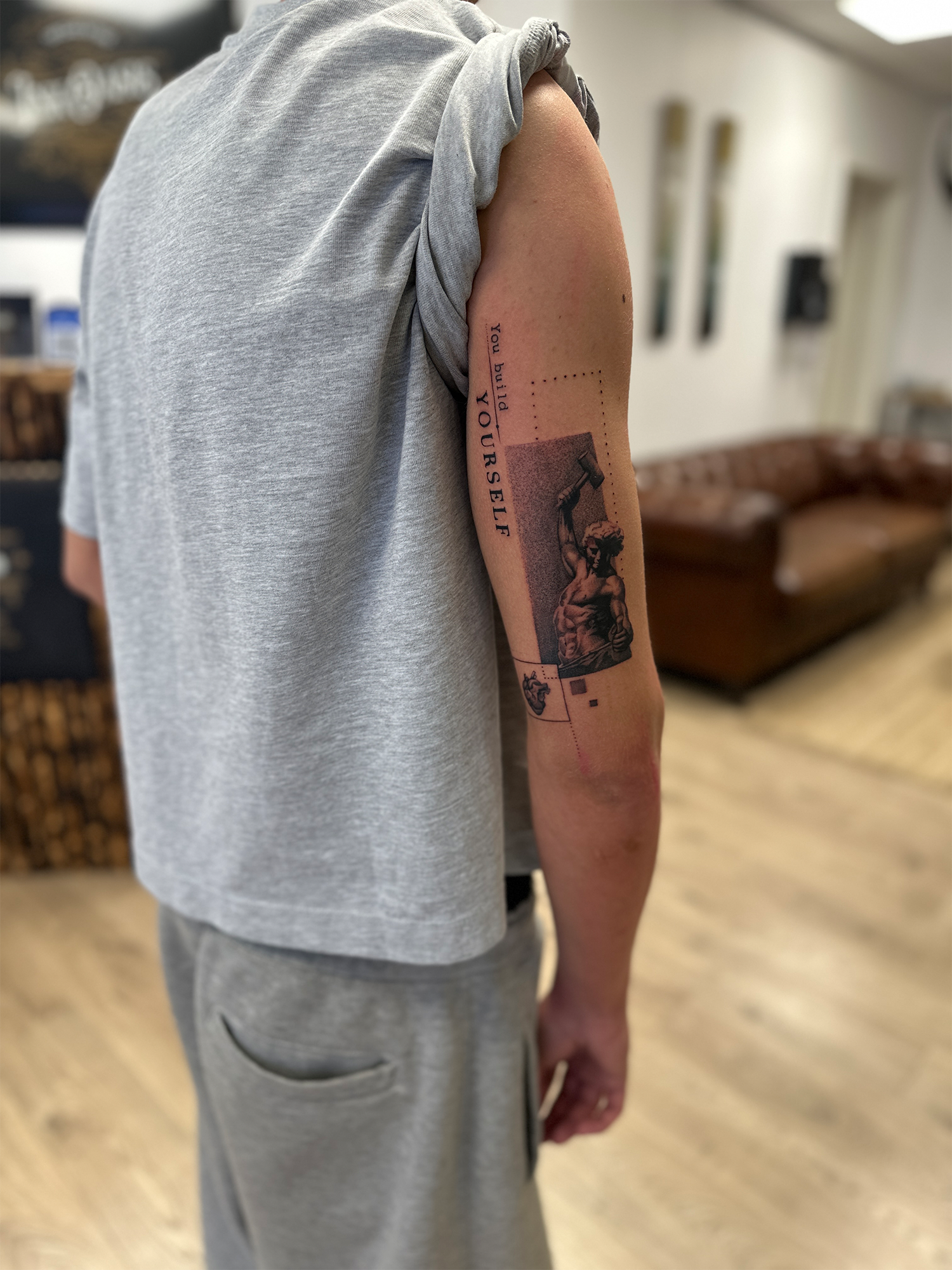 Sort/grå tatovering med fine detaljer og dybde med mikrorealistiske motiver