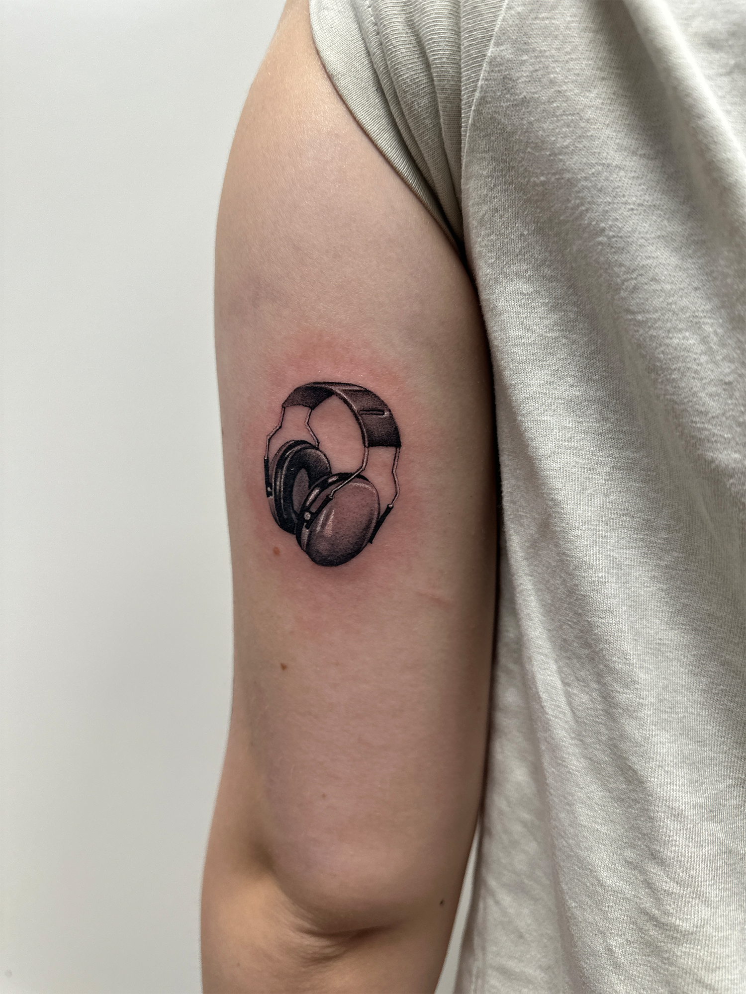 Sort/grå tatovering med fine detaljer og dybde med mikrorealistiske motiver